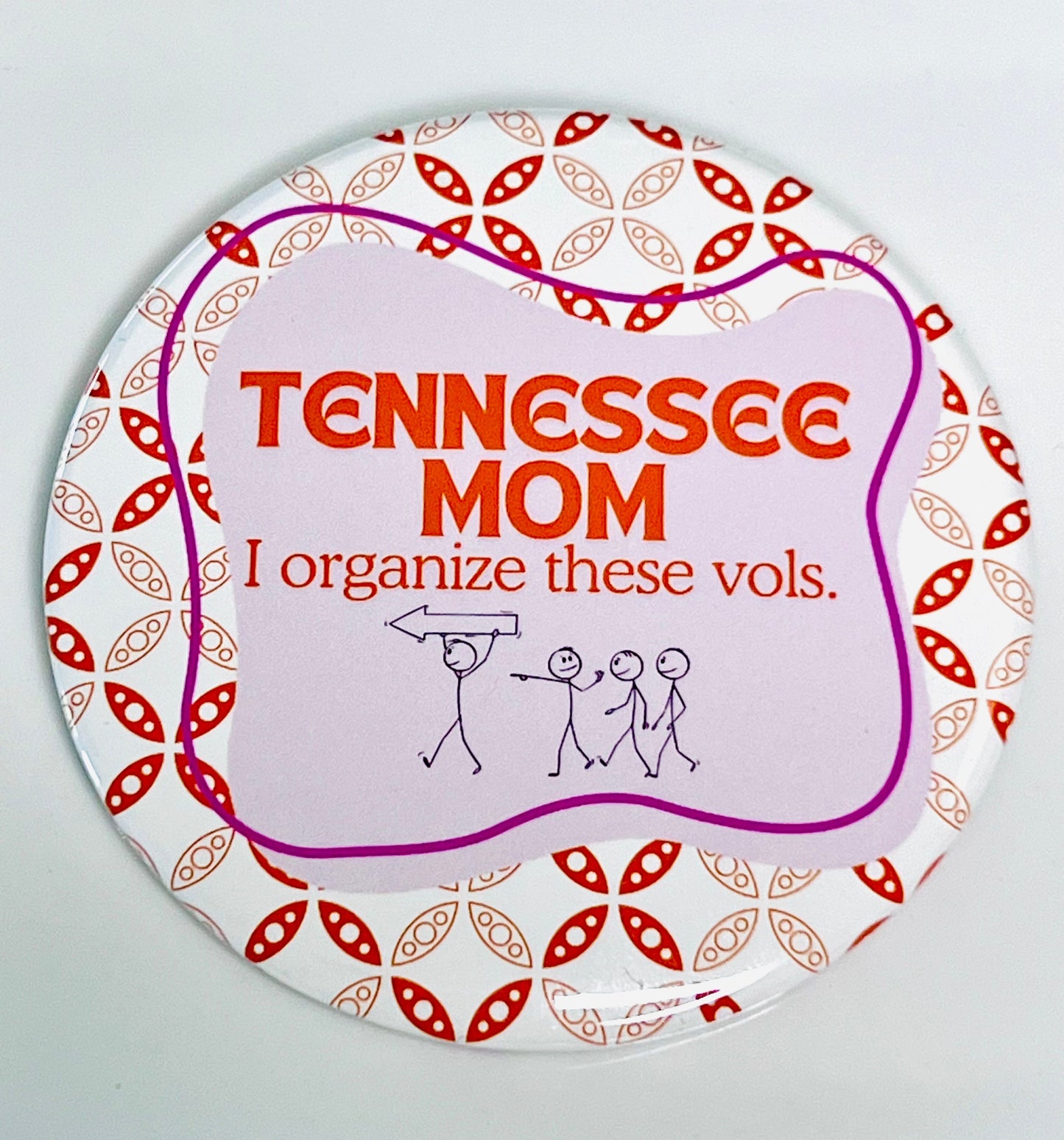 Round button with 'Tennessee Mom' text and stick people on pink and orange background