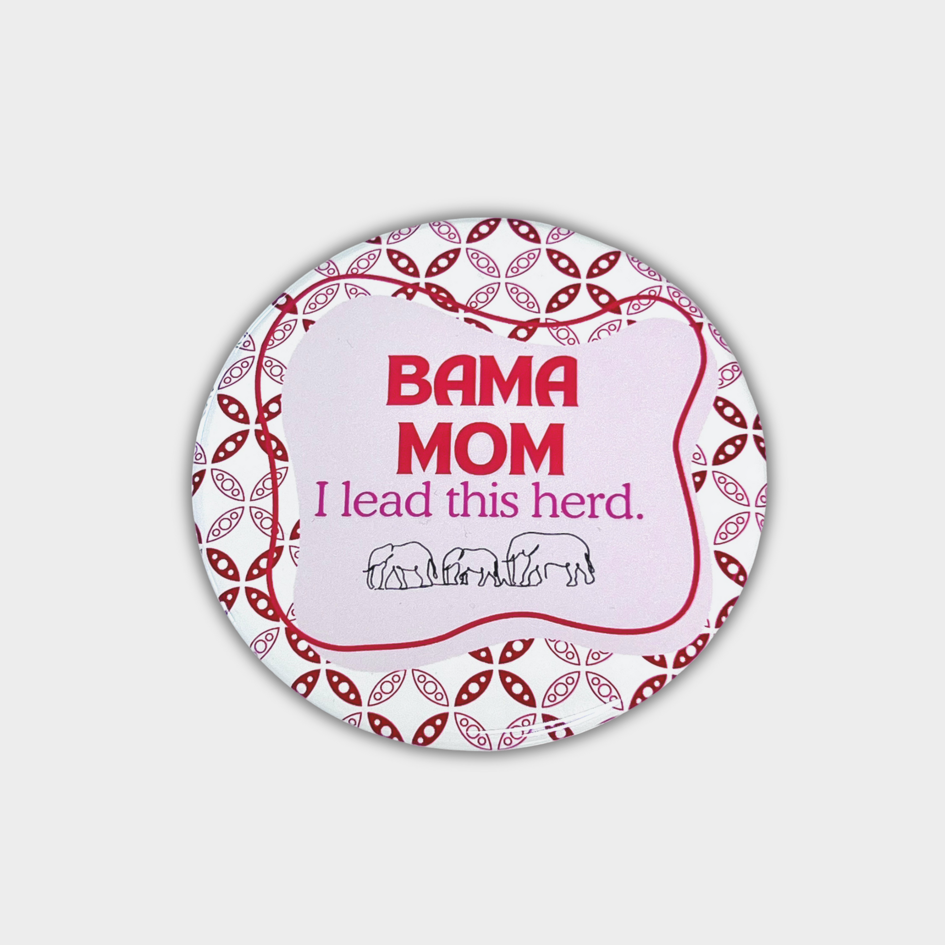 Round button with 'BAMA MOM I lead this herd' text and elephant illustrations on a pink and crimson, white patterned background