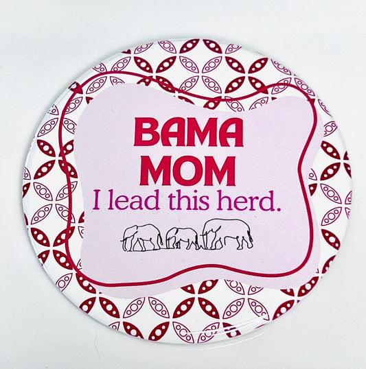 Round button with 'BAMA MOM I lead this herd' text and elephant illustrations on a pink and crimson, white patterned background