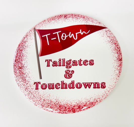 Circular button with a red flag and text 'T-Town Tailgates & Touchdowns' on a white background