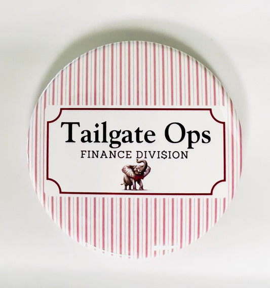 Round button with 'Tailgate Ops Finance Division' text and an elephant graphic on a red and white striped background.