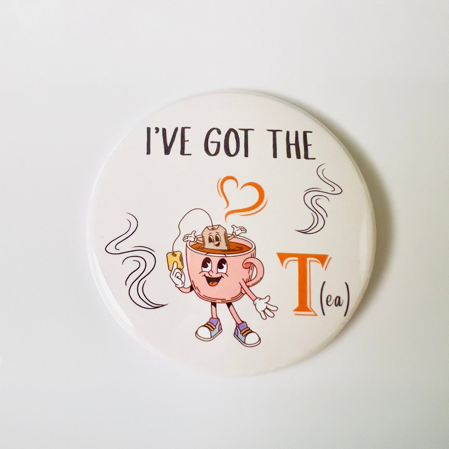 Round button with cartoon teacup character and text 'I've Got the Tea' on a white background