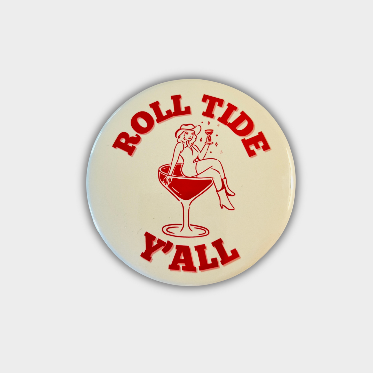 Circular button with 'Roll Tide Y'all' text and graphic on a beige background