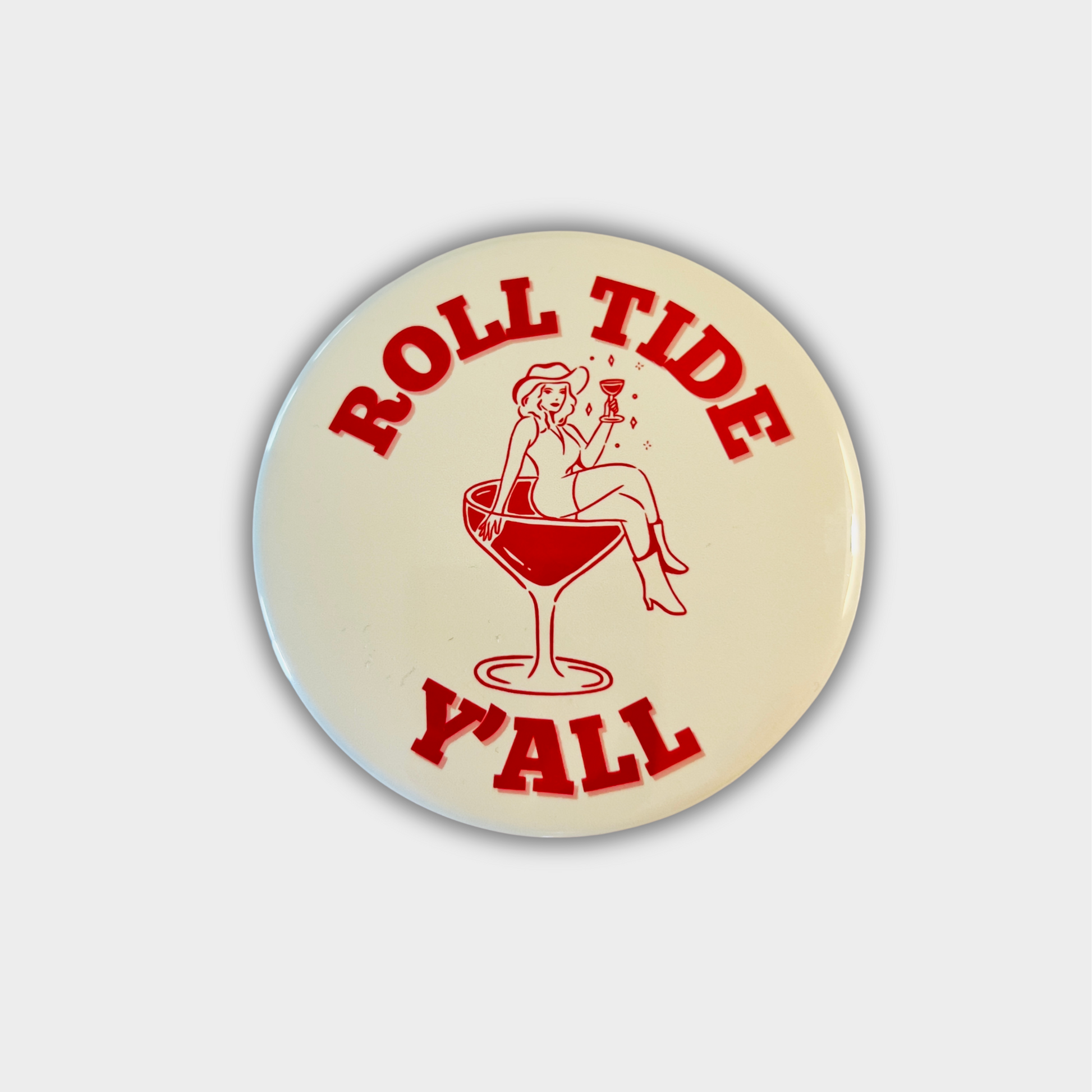 Circular button with 'Roll Tide Y'all' text and graphic on a beige background