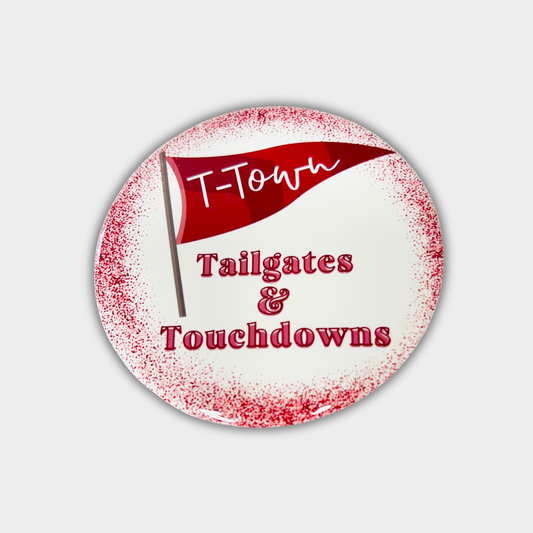 Round red and white round button with 'T-Town Tailgates & Touchdowns' text and flag design on a light gray background.