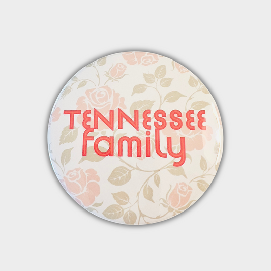 Round button with Tennessee Family text and orange and sage green 
floral background 